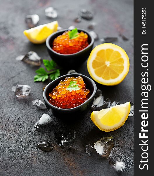 Red caviar in bowls on a old black background