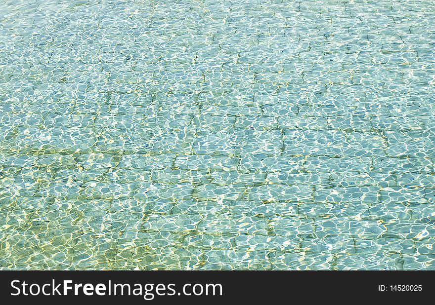 A water surface background with small waves and sun reflections