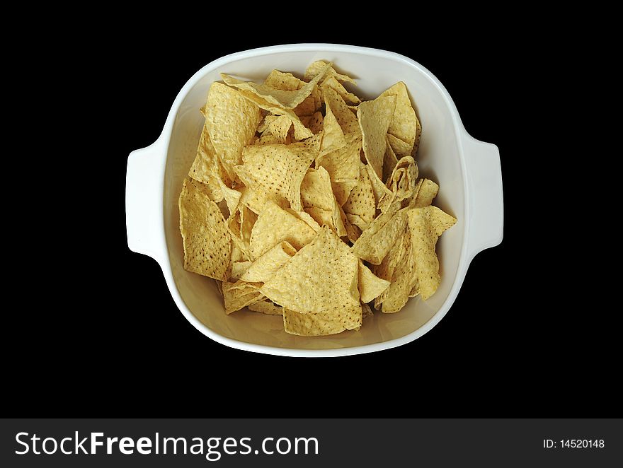 Corn tortilla chips contained in a white bowl isolated on black background. Corn tortilla chips contained in a white bowl isolated on black background.