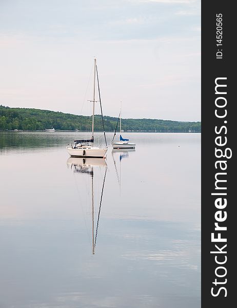 White sailboats on a quiet and peaceful lake