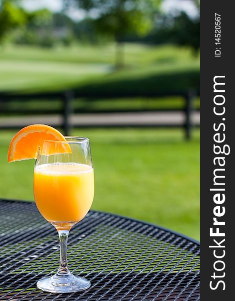 A refreshing glass of orange juice while sitting outdoors.