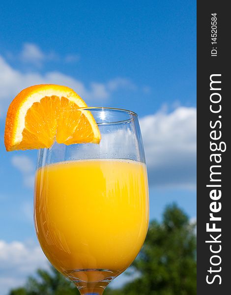 A refreshing glass of orange juice while sitting outdoors.