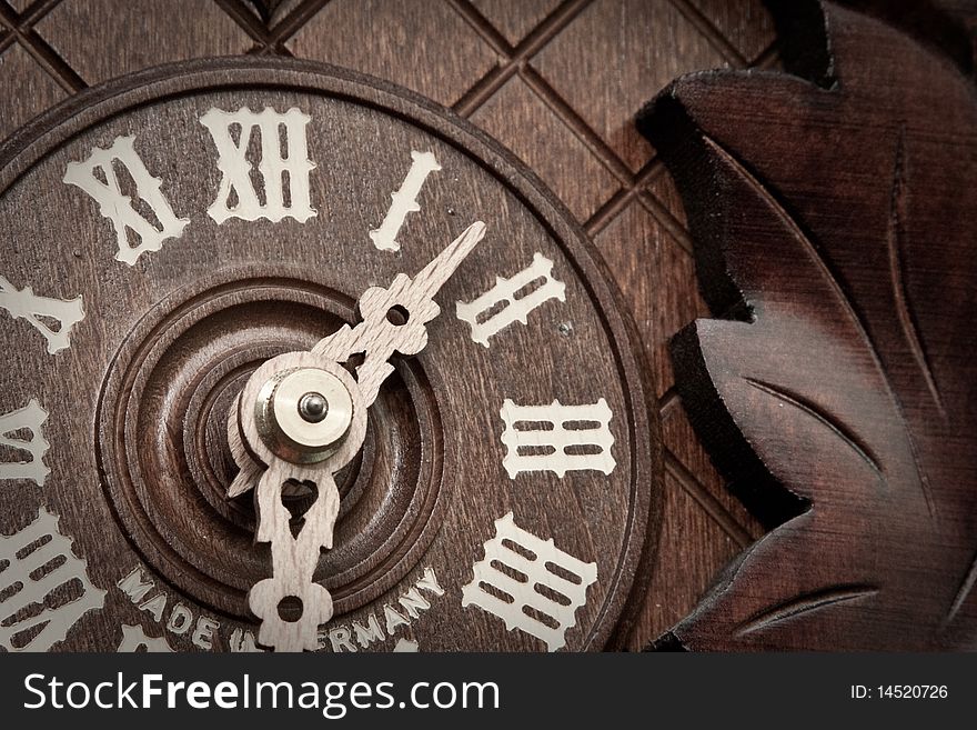 Close-up of an old wooden cuckoo clock with roman numerals. Close-up of an old wooden cuckoo clock with roman numerals