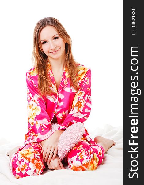 Sweet young girl in pink pajamas on bed