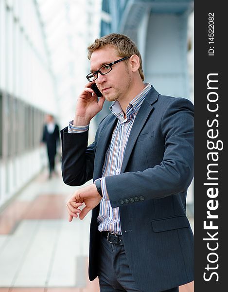 Businessman wearing glasses and a suit using a cell phone. Businessman wearing glasses and a suit using a cell phone