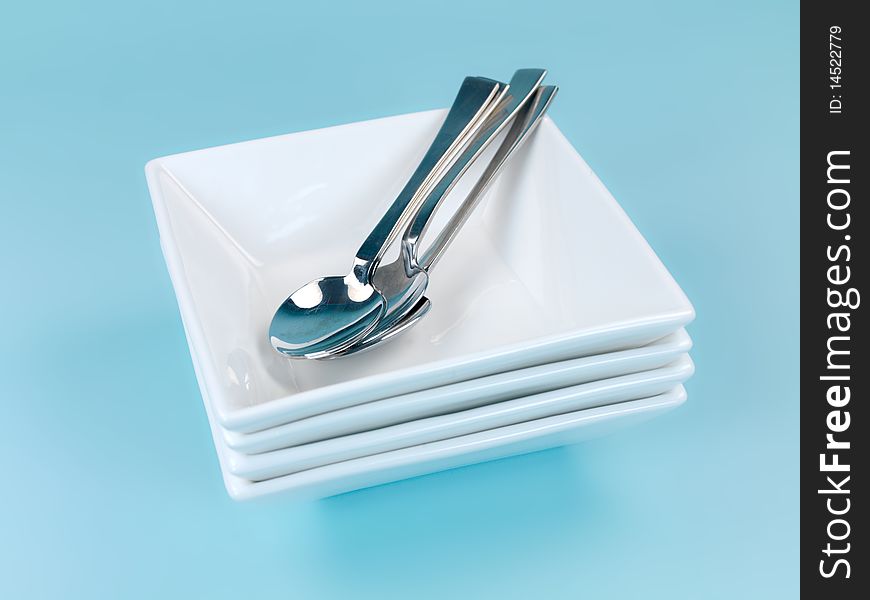 Plates and cutlery isolated against a blue background