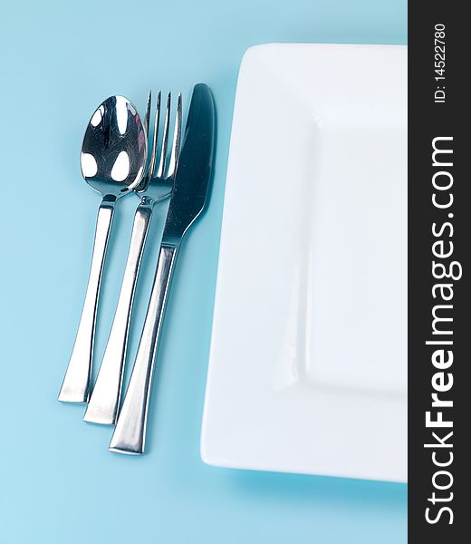 Plates and cutlery isolated against a blue background