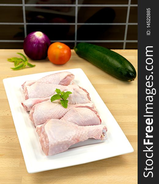 Raw chicken drumsticks on a kitchen bench