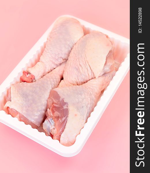 Raw chicken drumsticks on a kitchen bench