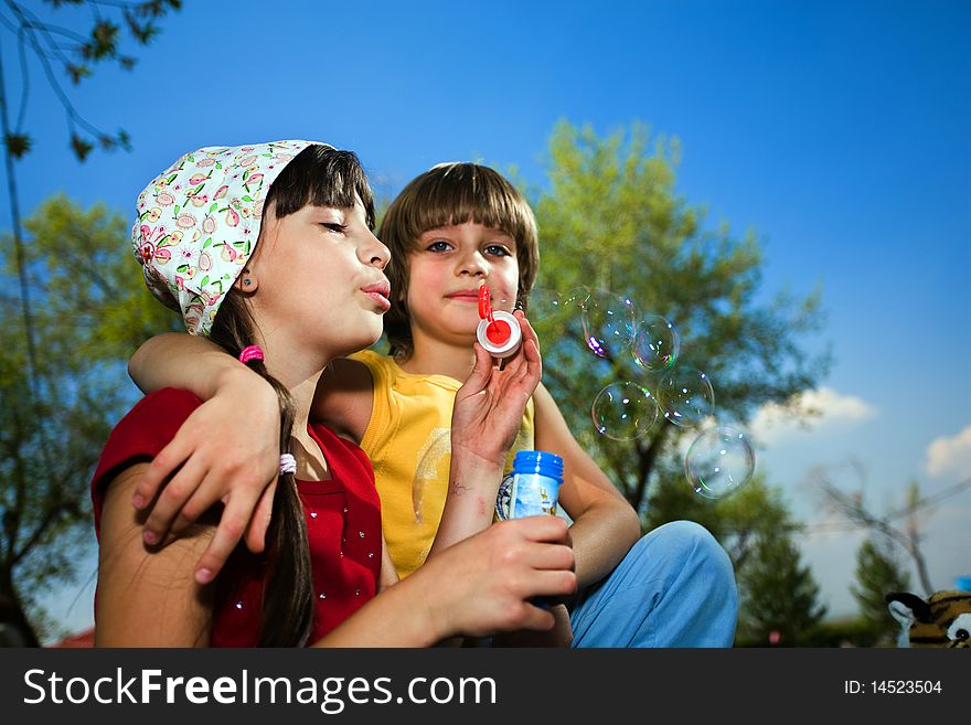 Girl with soap bubbles and boy in park