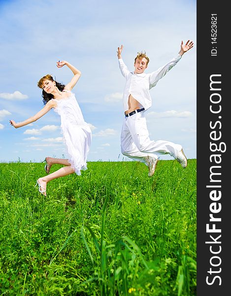 Couple jump in a flower field