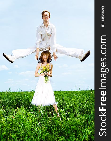 Cute couple jump in a flower field