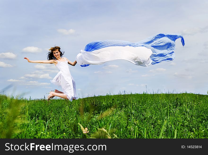 Happy young woman jumps. Sky as background