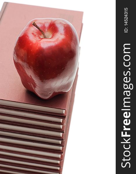 Stack of books and apple isolated over white