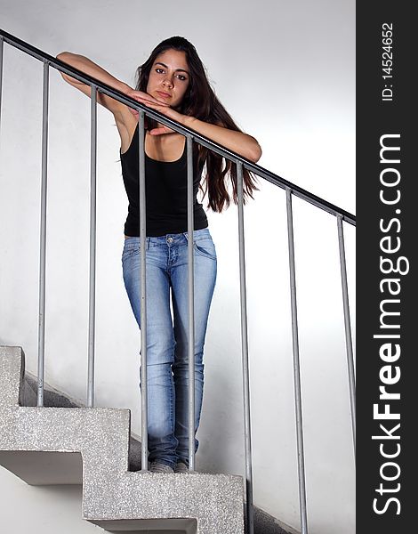 Beautiful young woman leaning on staircase railing. Beautiful young woman leaning on staircase railing