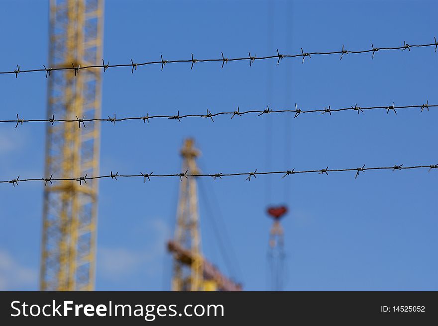 Elevating construction crane against the blue sky in a fair weather