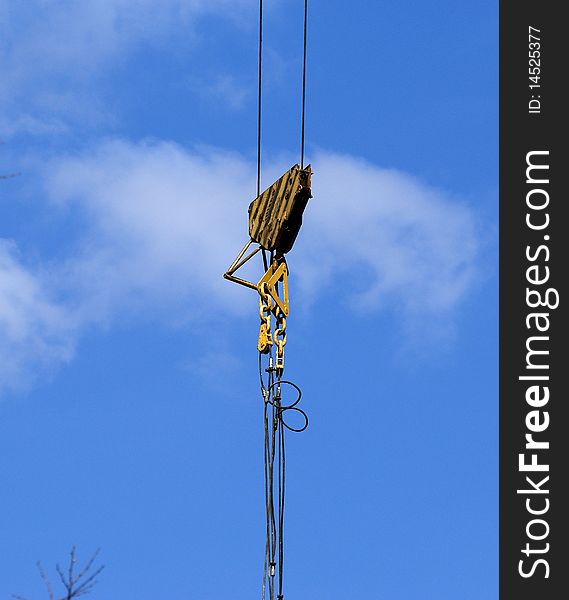 Elevating construction crane against the blue sky in a fair weather