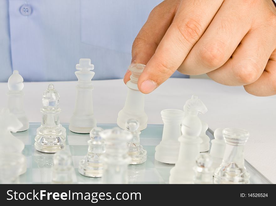 Man making a move on a glass chess. Man making a move on a glass chess