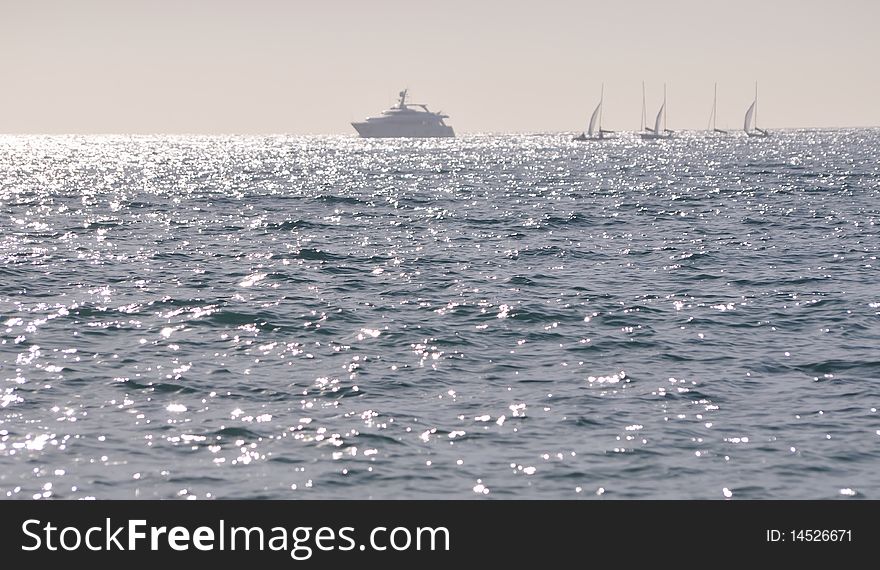 Panoramic seascape of Mediterranean Sea in the Barcelona area with yachts and clear sky; sharp focus on sea waves in the middle. Panoramic seascape of Mediterranean Sea in the Barcelona area with yachts and clear sky; sharp focus on sea waves in the middle