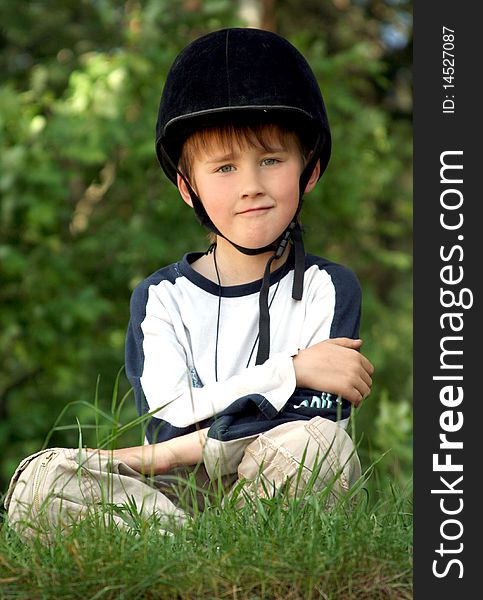 The boy in a cap of the equestrian on  greens