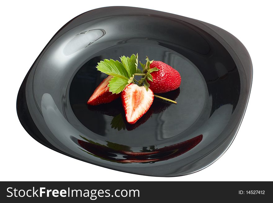 Fresh ripe strawberry on black dish isolated on white