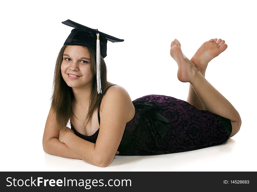 An attractive barefoot teen reclining in her middle-school graduation cap with her graduation dress. Isolated on white. An attractive barefoot teen reclining in her middle-school graduation cap with her graduation dress. Isolated on white.