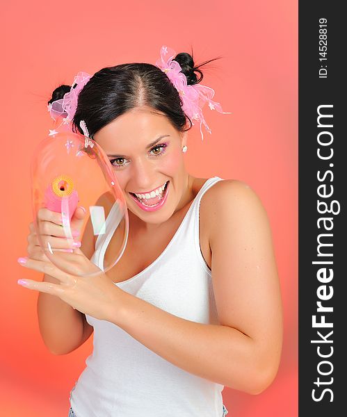 Beautiful happy teenage girl blowing soap bubbles and havinh fun. pink background