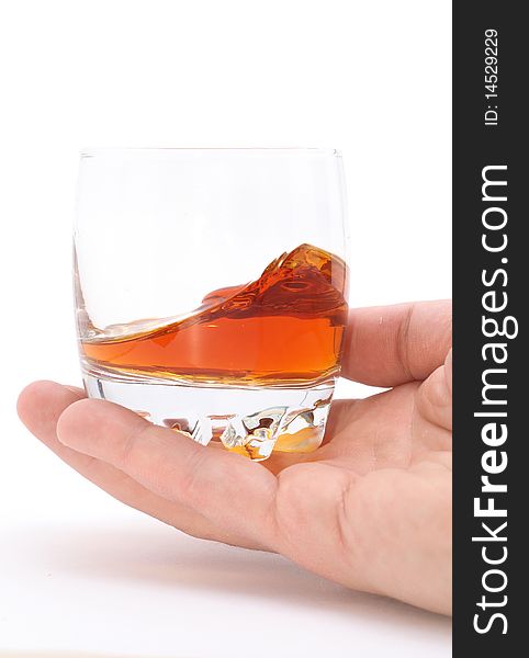 Glass of brandy holding by hand isolated on white