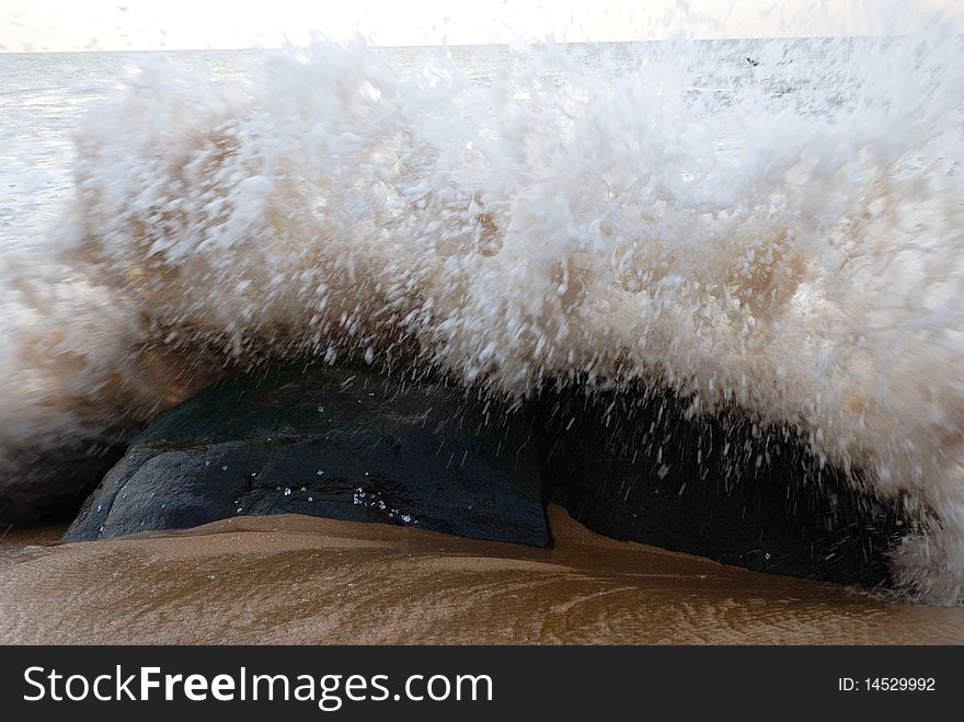 Sea wave captured, over a rock