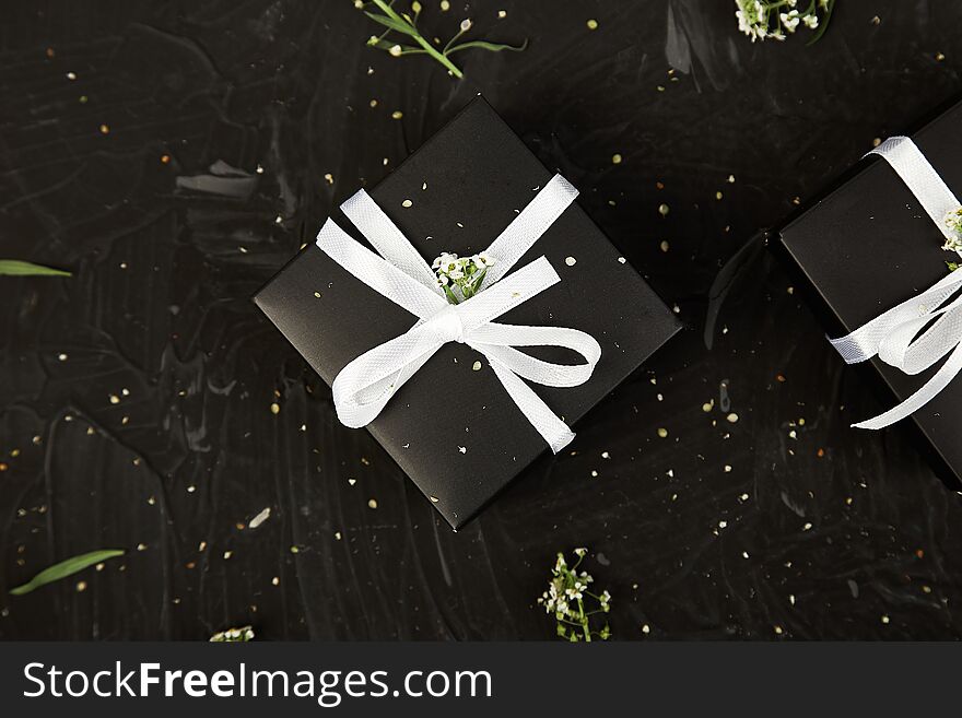 Wrapping modern Christmas or Birthday gifts presents. Gift boxes in Black and White color with flowers. Flat lay, top view. Beautiful