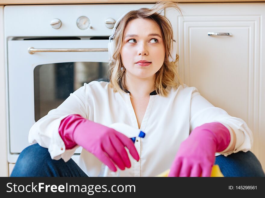 So tired. Nice young woman sassing near the oven while being tired after cleaning the kitchen. So tired. Nice young woman sassing near the oven while being tired after cleaning the kitchen