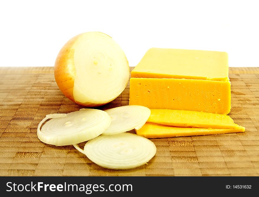 Sliced Yellow Gouda Cheese and Brown Onion on a wooden chopping board with a white background. Sliced Yellow Gouda Cheese and Brown Onion on a wooden chopping board with a white background