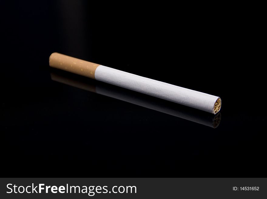 Cigarette on a black reflective background