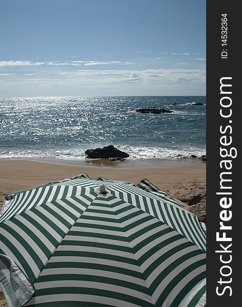 Green and white stripes umbrella at the beach