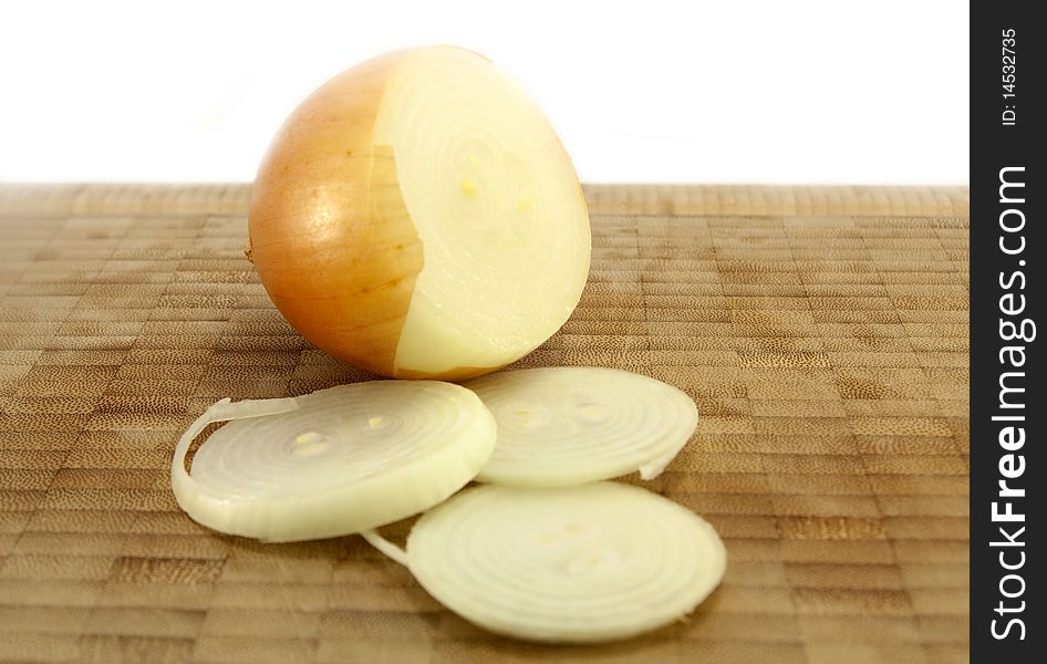 Sliced Organic Brown Onion on a wooden chopping board isolated on a white background. Sliced Organic Brown Onion on a wooden chopping board isolated on a white background