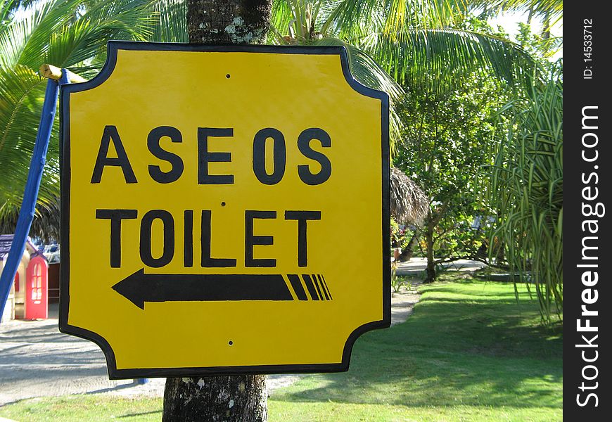 Spanish toilet sign in tropical environment