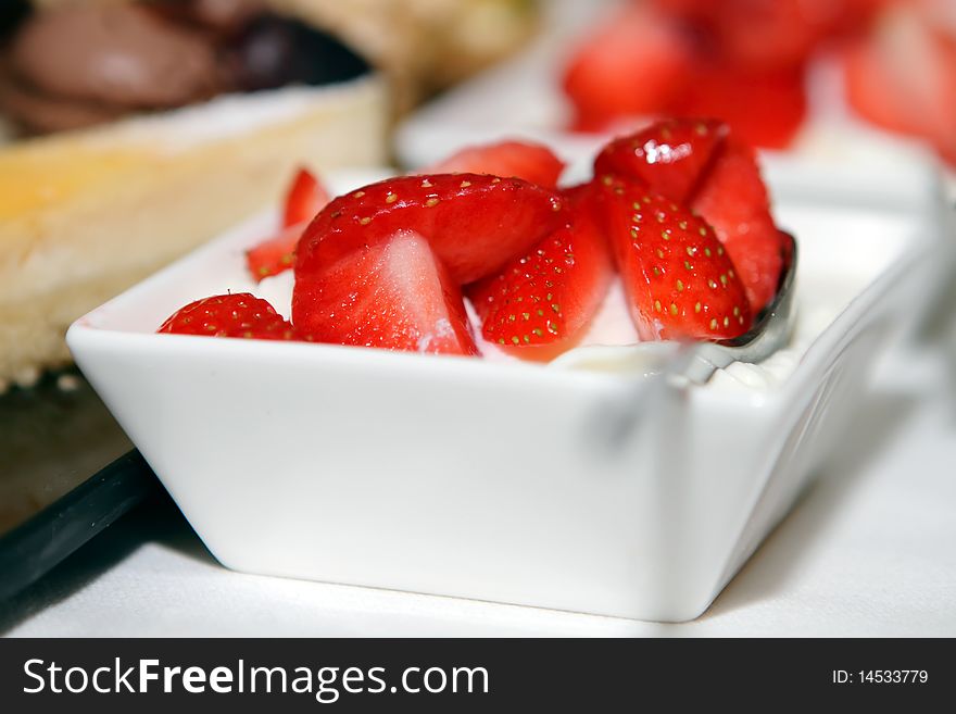 Fresh strawberries with whipped cream in dishes on the table