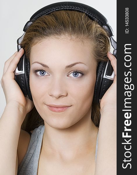 Beautiful young girl in headphones over white. Beautiful young girl in headphones over white