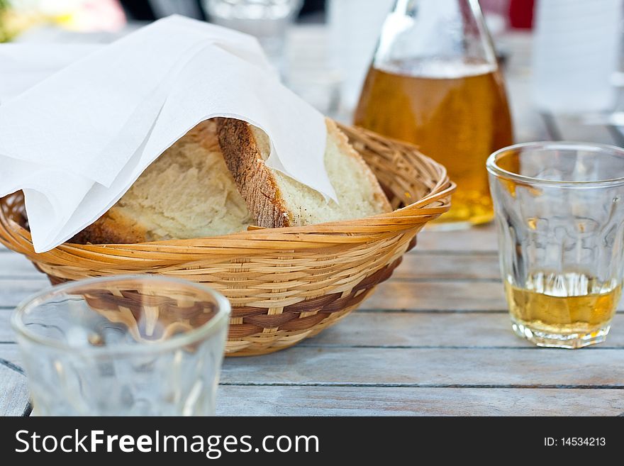 Wicker basket with bread and glass of white wine. Wicker basket with bread and glass of white wine