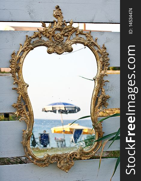 Mirror on the beach reflects umbrellas and chairs