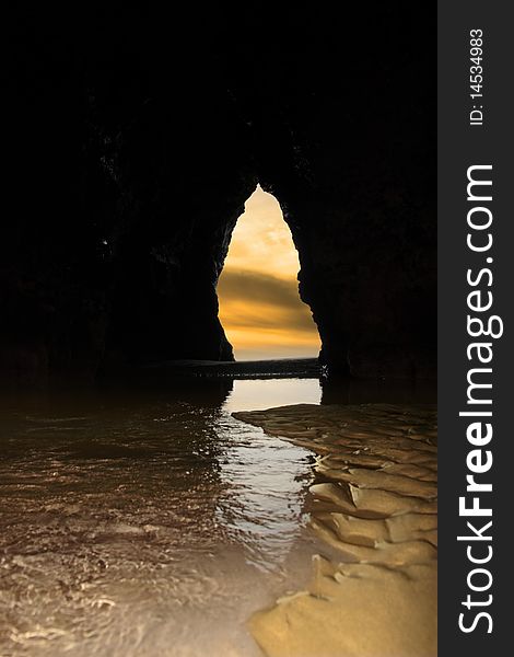 A view from the inside of a beach cave looking out at the sea. A view from the inside of a beach cave looking out at the sea