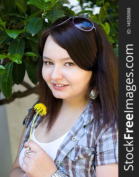 Portrait of a young dark-haired girl with a dandelion. Portrait of a young dark-haired girl with a dandelion