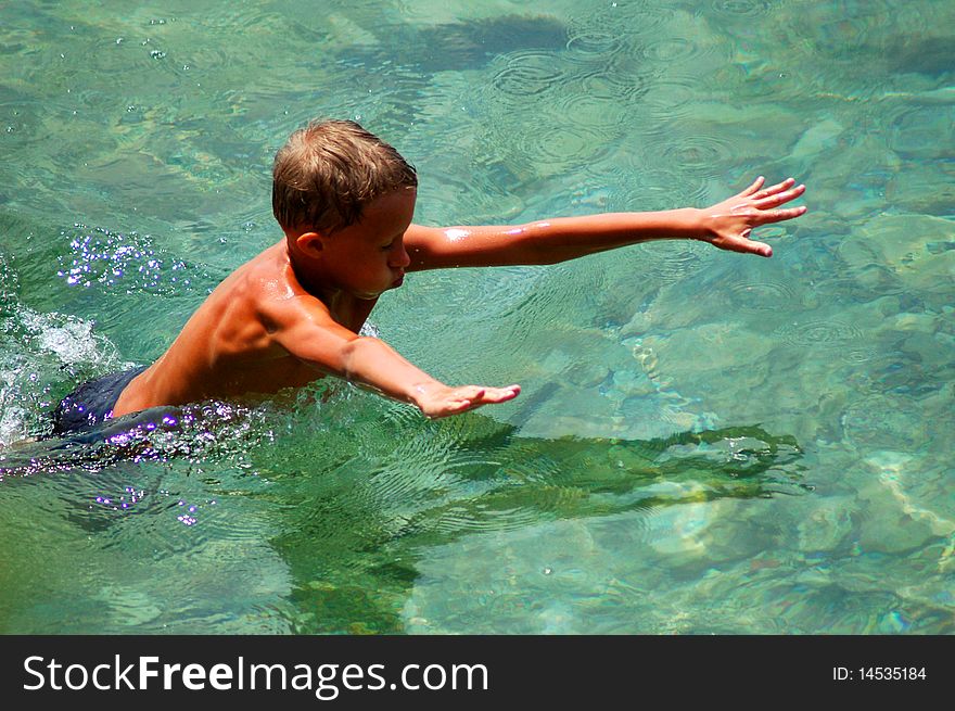 A boy is learning to swim in adriatic water