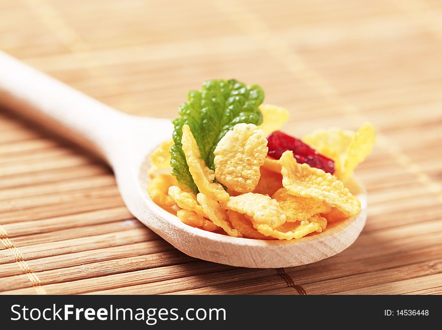 Corn flakes on a wooden spoon - detail. Corn flakes on a wooden spoon - detail