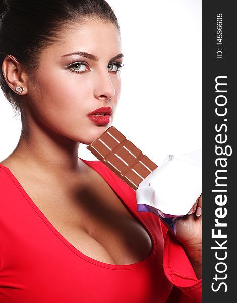 Young beautiful woman in red dress eating chocolate. Young beautiful woman in red dress eating chocolate