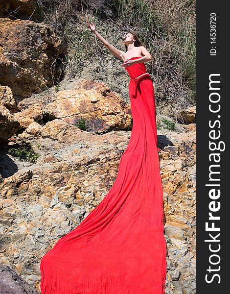 Woman in red dress from material and rocks