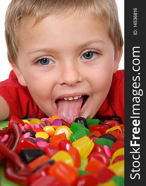 Young boy being with a table full of colorful sweets