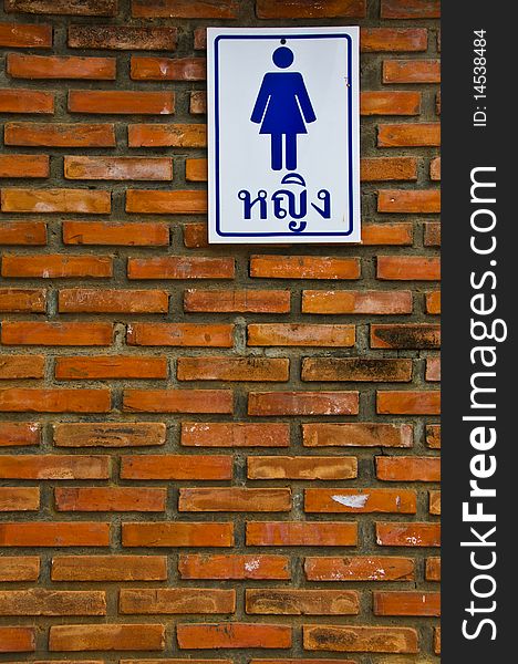Brick Wall With Blue And White Sign
