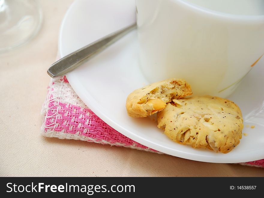 Healthy cookies half eaten with white cup and saucer. A healthy and nutritious afternoon snack. Concepts such as food and beverage, diet and nutrition, and healthy lifestyle. Healthy cookies half eaten with white cup and saucer. A healthy and nutritious afternoon snack. Concepts such as food and beverage, diet and nutrition, and healthy lifestyle.