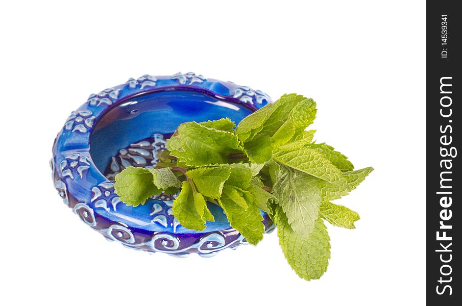 Ceramic ashtray with green mint isolated on a white background